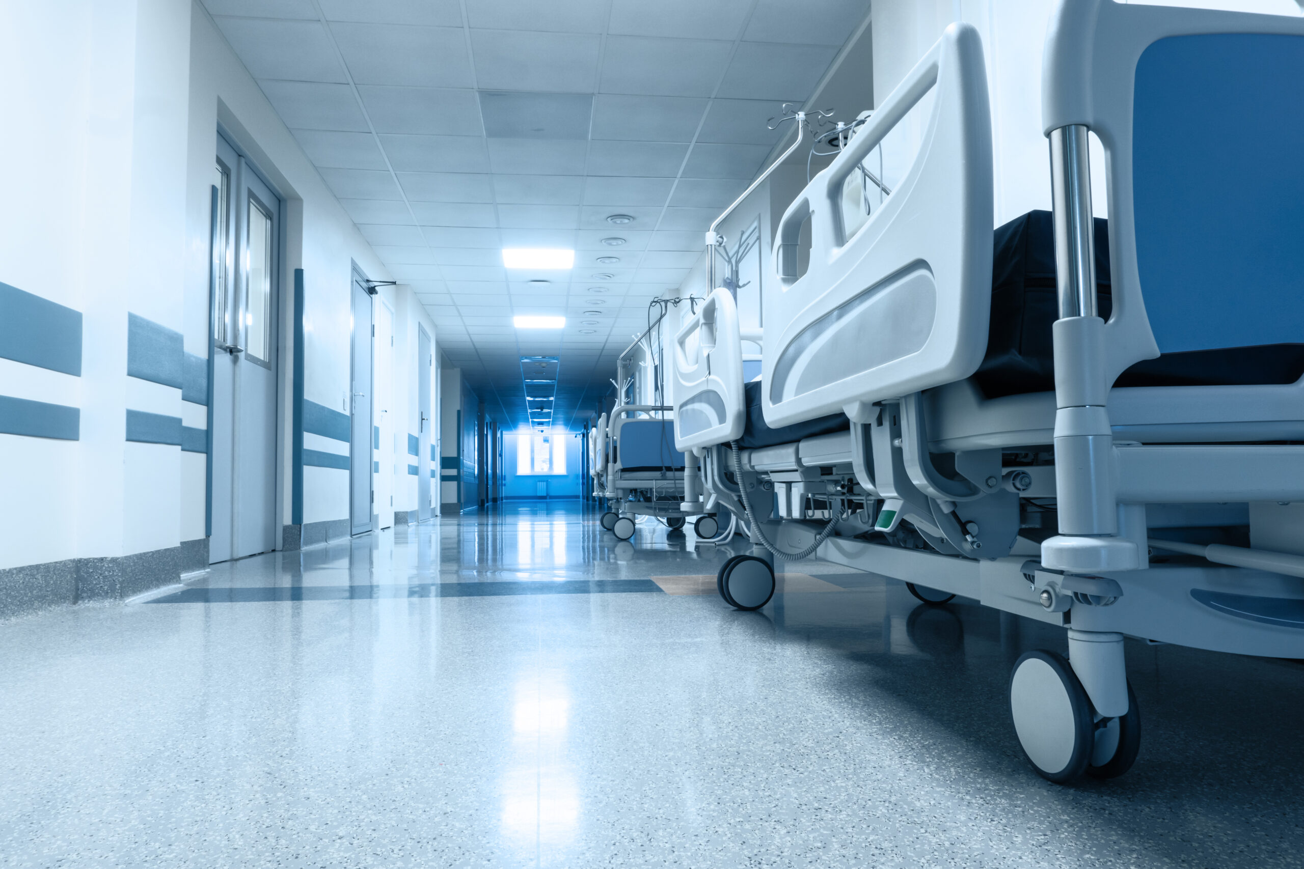 Hospital beds lining hallway in healthcare facility